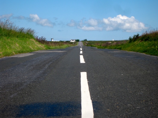 Huvudvägen, som går från Port Ellen upp till Port Askaig, på Islay. Flygledartornet på öns lilla flygplats (Islay Airport/ILY) syns till vänster.